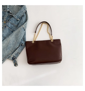 Close-up of deep brown chain shoulder bag with gold hardware on white background