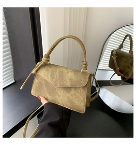 Detail of vintage crossbody bag in olive green with knotted handle and matte texture