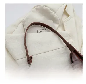 Close-up of brown crocodile texture leather on minimalist crescent underarm bag
