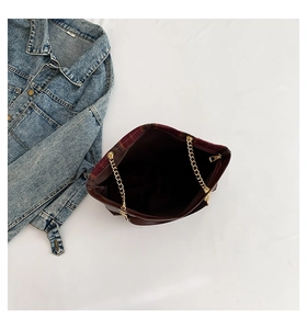 Deep reddish brown handbag interior showing brown lining and golden chain strap detail