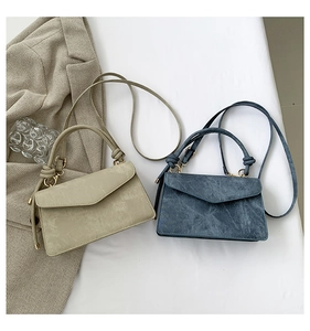 Close-up of minimalist small square handbags in beige and denim blue colors