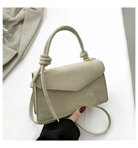 Detail of olive green suede textured mini crossbody bag with knotted round handle