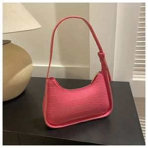 Dettaglio della borsa sottobraccio rosa brillante con trama in ecopelle stampa coccodrillo