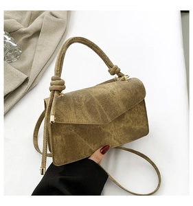 Detailed macro view of olive green retro canvas square bag with knotted handle and metal hardware