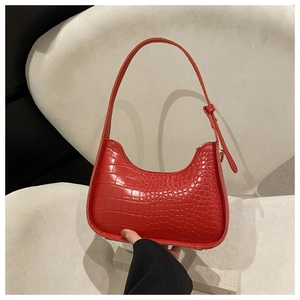 Dettaglio borsa hobo rossa con trama a coccodrillo, texture premium e fibbie dorate