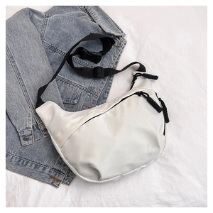Detail of white nylon dumpling bag featuring adjustable wide strap and chunky zipper puller