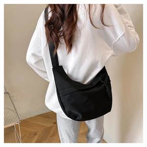 Rear view of a minimalist black crescent nylon bag with adjustable wide shoulder strap