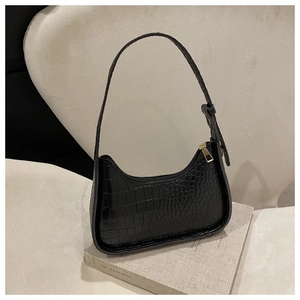 Dettaglio della trama a coccodrillo nera in ecopelle su una borsa a spalla elegante