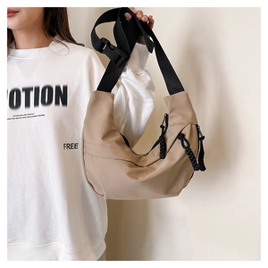 Detail of khaki crescent crossbody nylon bag with adjustable wide strap on model
