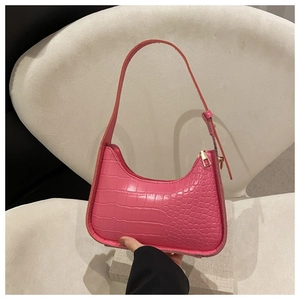 Dettaglio borsa sottobraccio rosa effetto coccodrillo con zip dorata e finta pelle