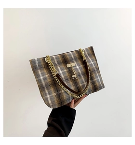 Detail of checkered woolen tote bag with gold chain strap and deer metal charm