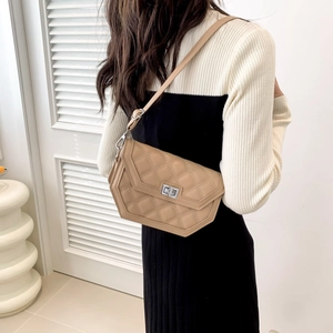 Detailed view of khaki quilted crossbody bag with silver twist lock on a modern model