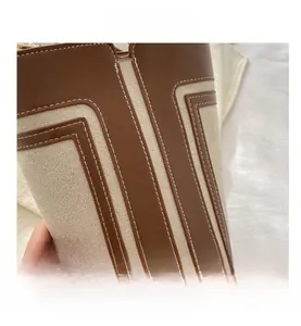 Dettagli in pelle marrone e tela crema cuciti sulla borsa a secchiello chic