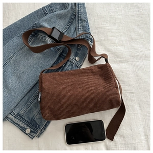 Detail of brown corduroy tote bag showing textured fabric and adjustable shoulder strap