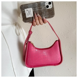 Dettaglio borsa a spalla fucsia con trama a coccodrillo e cerniera in metallo dorato
