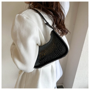 Borsa a spalla a mezza luna con motivo a coccodrillo indossata da una modella nera
