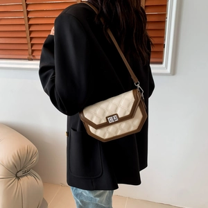 Close-up of quilted crossbody bag with dual-tone design and square metallic clasp lock
