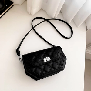 Macro detail of black quilted hexagonal crossbody bag with silver rotating lock closure