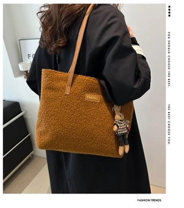 Brown fuzzy tote bag with leather strap and cute bunny pendant shown from behind