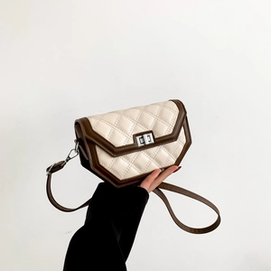 Close-up of quilted rhombic pattern shoulder bag with silver lock and brown trim details