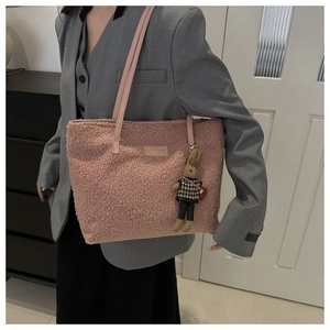 Detail of pink plush tote bag with soft texture and cute rabbit doll keychain