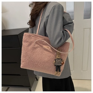 Pink plush tote bag with bunny charm and FASHION label shown in lifestyle setting