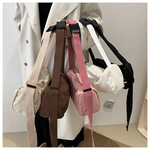 Close-up of corduroy cylindrical crossbody bags in multiple colors with adjustable straps