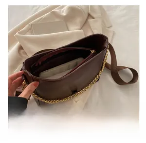 Detail view of the spacious inner compartment and zipper pocket of the brown shoulder bag