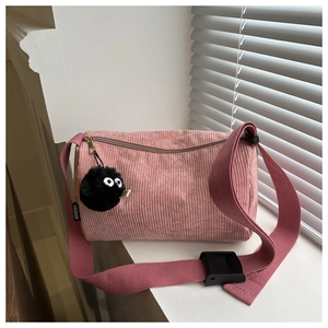 Detail of pink corduroy tote bag featuring FASHION label and cute plush coal sprite charm