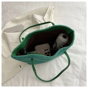 Interior detail of large green plush tote showing spacious storage for daily items