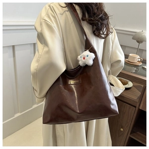 Deep brown faux leather tote bag worn by a model in a cozy cafe setting for daily commuting