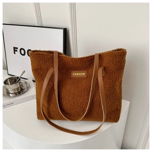 Detailed texture of brown fleece tote bag with leather handles and fashion logo