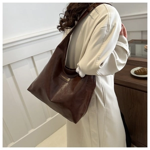 Detail of dark brown tote bag with FASHION & BAGS print and glossy pleated leather texture