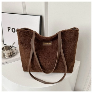 Detail of dark brown plush tote bag showing soft faux shearling and leather shoulder strap