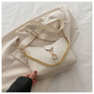 Detail of cream leather bucket bag with gold chain strap and stylish clasp closure