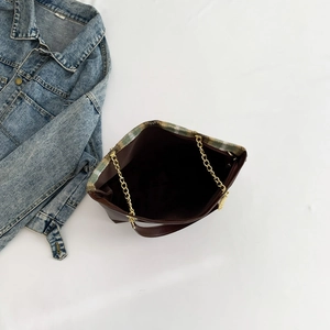 Brown vintage chain tote bag with woven trim and spacious interior on blue denim