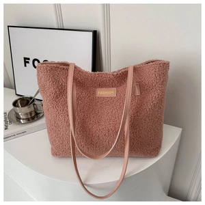 Close-up of pink plush tote bag with yellow FASHION label and soft faux fur texture