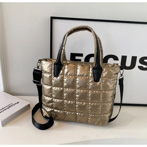 Metallic gold quilted tote bag with black handles and adjustable wide crossbody strap