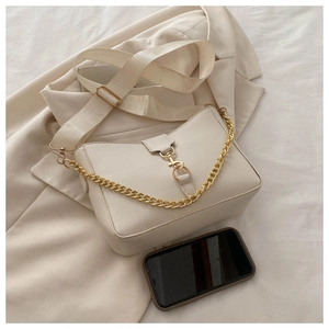 Detail of cream bucket bag with gold metal hook closure and wide fabric strap