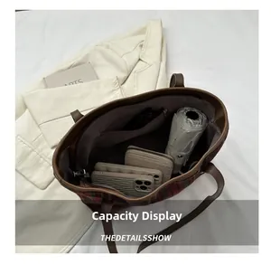 Top view of spacious interior plaid tote bag with brown leather handles and zipper pocket