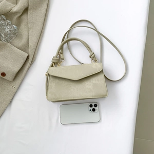 Sage green minimalist envelope handbag with knot handle and slim strap on white fabric