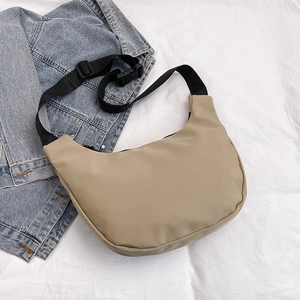 Minimalist beige nylon half-moon crossbody bag with adjustable black strap and casual style