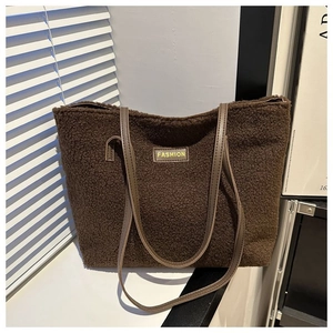 Detailed view of brown plush tote bag with FASHION leather tag and soft faux fur texture