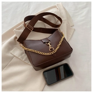Detail of dark brown bucket bag with gold chain and phone for size comparison