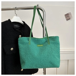 Detail of green faux fur tote bag with long leather straps and fashion label tag