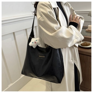 Detail of black faux leather tote bag with star pendant and Fashion & Bags tag