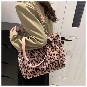 Detail of pink leopard faux fur tote bag with metal chain strap on khaki blazer
