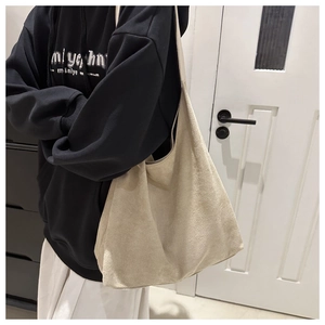 Detailed texture of off-white suede tote bag in a casual lifestyle setting