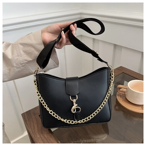 Detail of a black PU leather shoulder bag with gold chain and wide nylon strap
