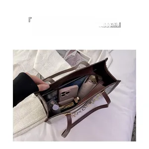 Détail du sac cabas marron foncé montrant les compartiments internes et le rangement